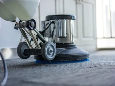 Machine professionnelle nettoyant une moquette, utilisée pour l’entretien des sols textiles.